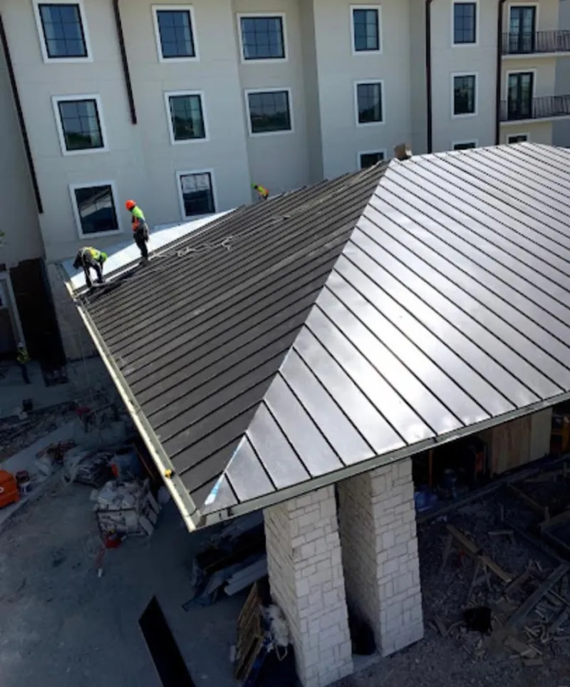 Crew installing standing seam metal roof panels on a commercial project in Rohnert Park